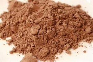 Cocoa powder piled on a white surface.