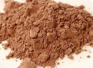 Cocoa powder piled on a white surface.