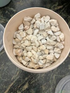 Container filled with small, light-colored stones.