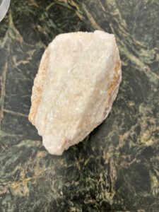 Rough stone resting on a dark surface.