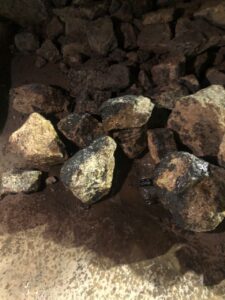 Wet rocks scattered on a dark surface.